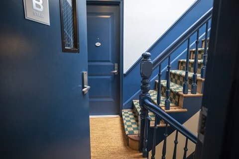 A staircase with a blue door and a sign that says B stair.