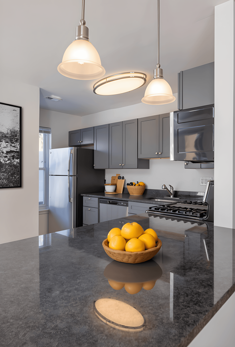 A kitchen with a bowl of lemons on the counter.