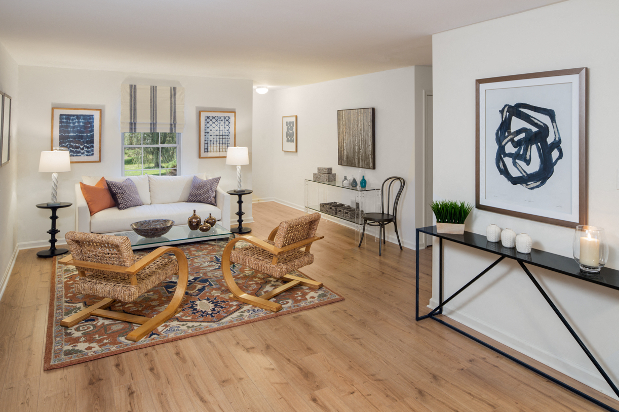 A living room with a rug, chairs, and a fireplace.