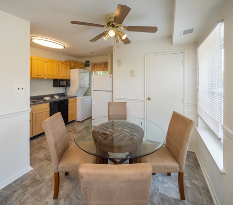 A kitchen with a glass table and chairs.