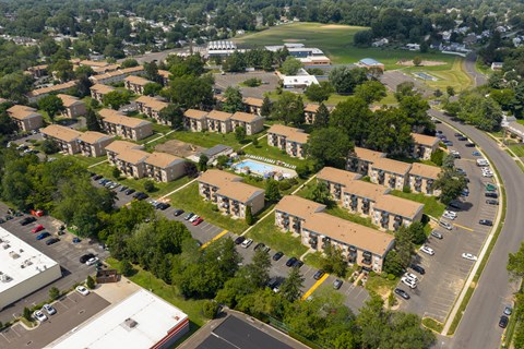A large apartment complex with a swimming pool in the middle.