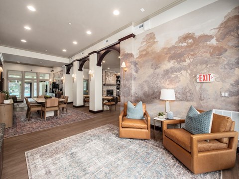 A living room with a large rug and a painting on the wall.