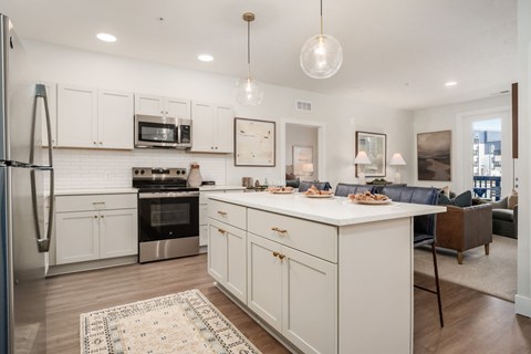 A kitchen with white cabinets and a black oven.