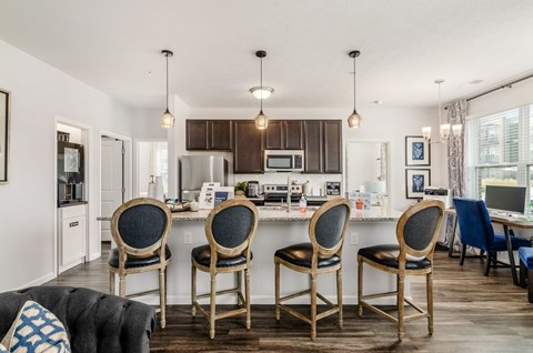 A kitchen with a table and chairs in front of it.