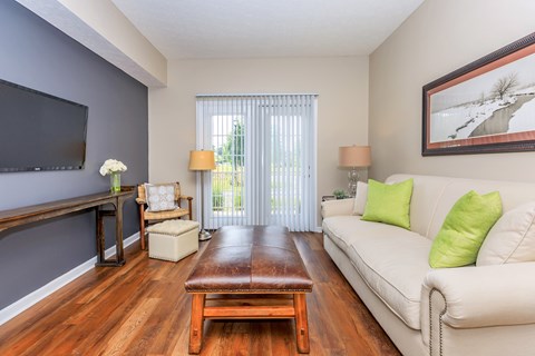 A living room with a white couch and a wooden coffee table.