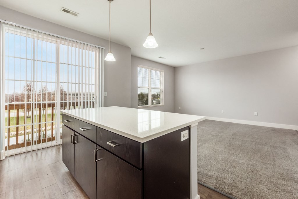 A kitchen with a white countertop and black cabinets.
