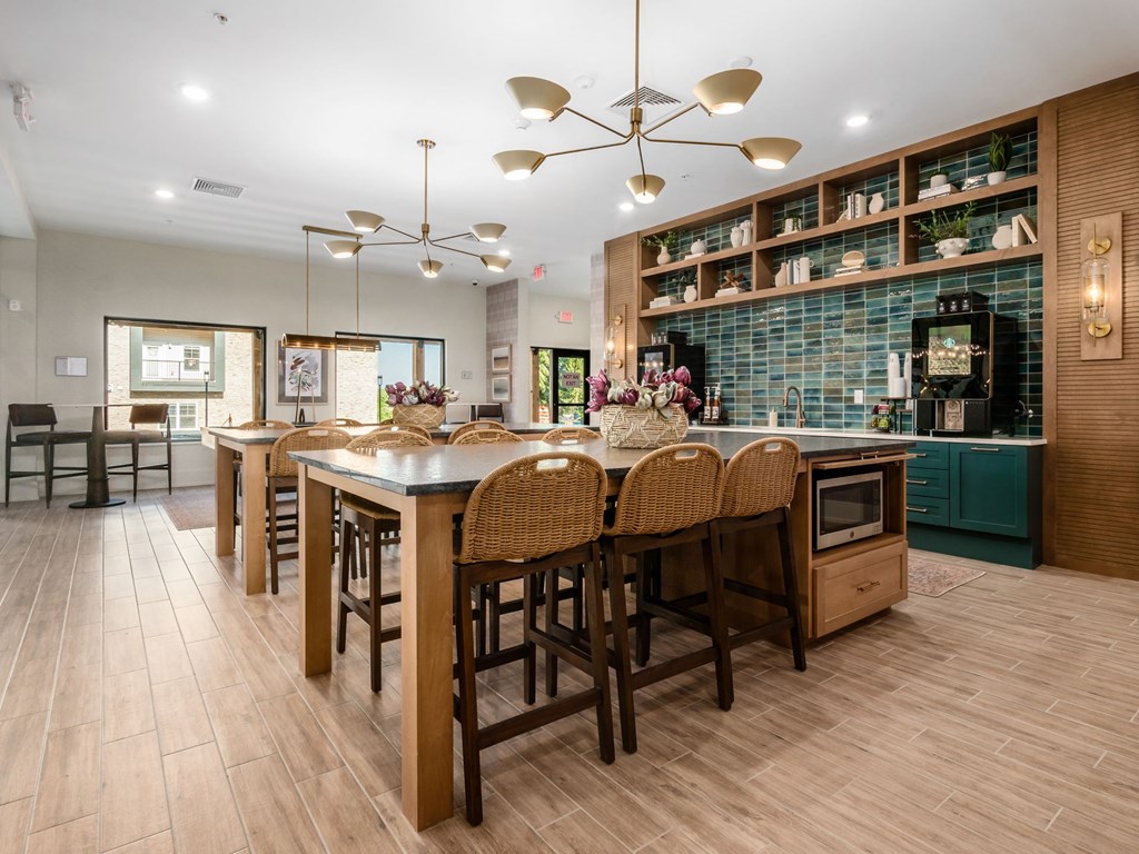 A kitchen with a long table and chairs.