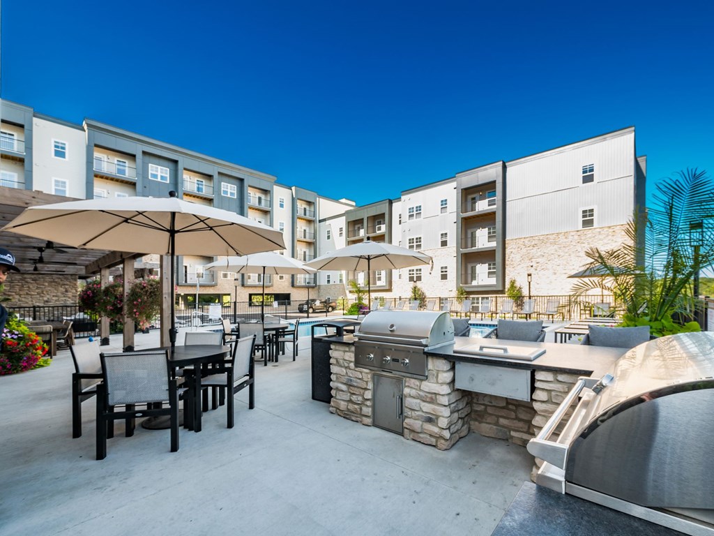 A patio area with tables and chairs and umbrellas is shown.