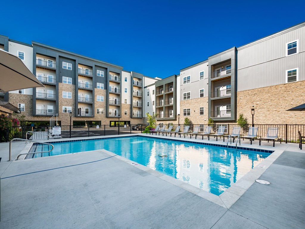 A swimming pool in front of apartment buildings.