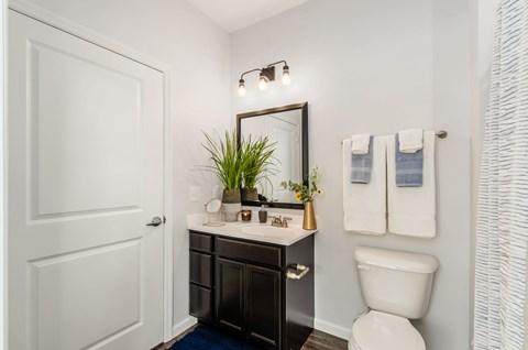 A white toilet sits next to a white sink in a bathroom.