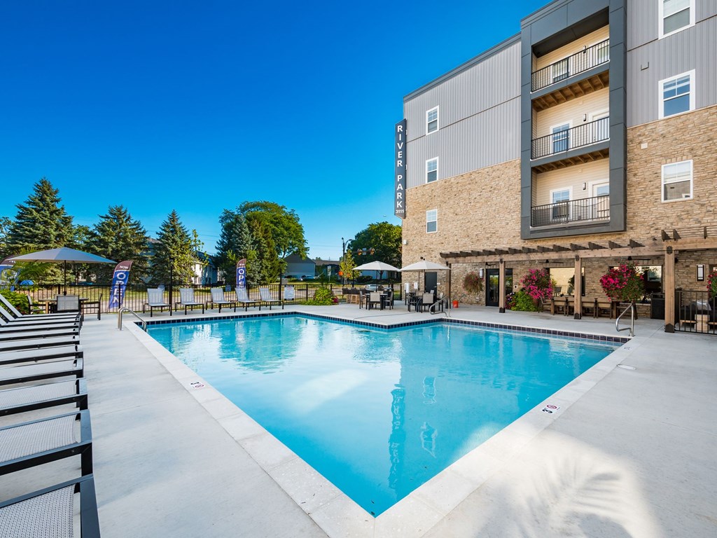 A large swimming pool in front of a building with a sign that reads