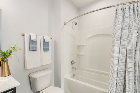 A white bathroom with a toilet, sink, and bathtub.