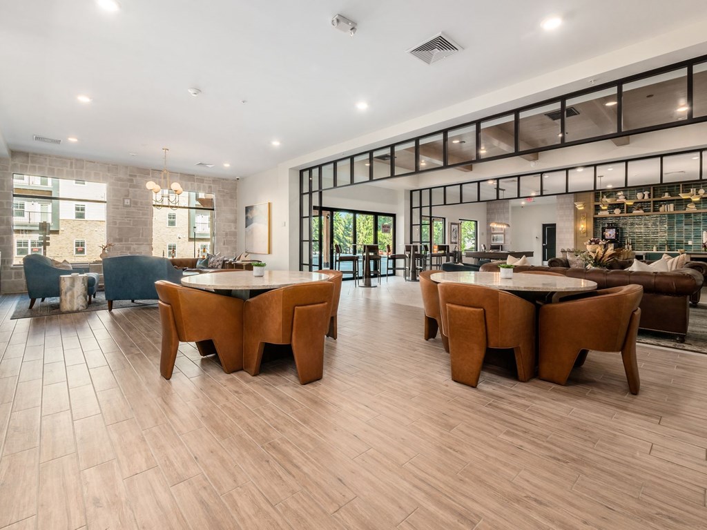 A spacious room with wooden floors and a long table surrounded by chairs.
