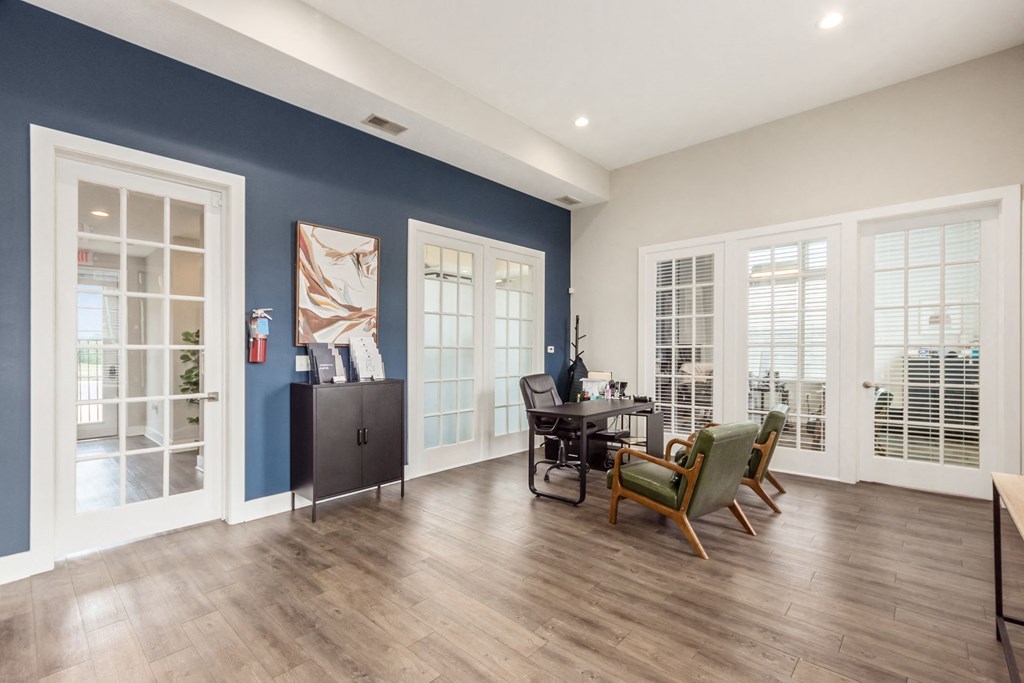 A room with a desk and chairs in it.