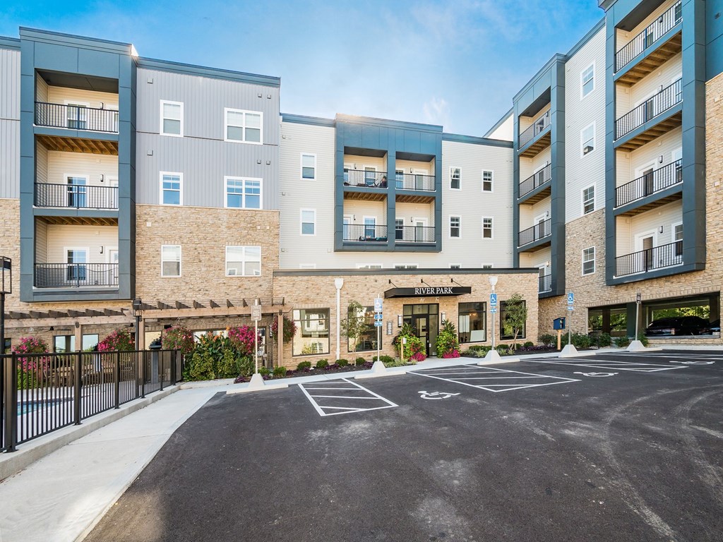 A modern apartment complex named Riverfront is shown with a parking lot in front.