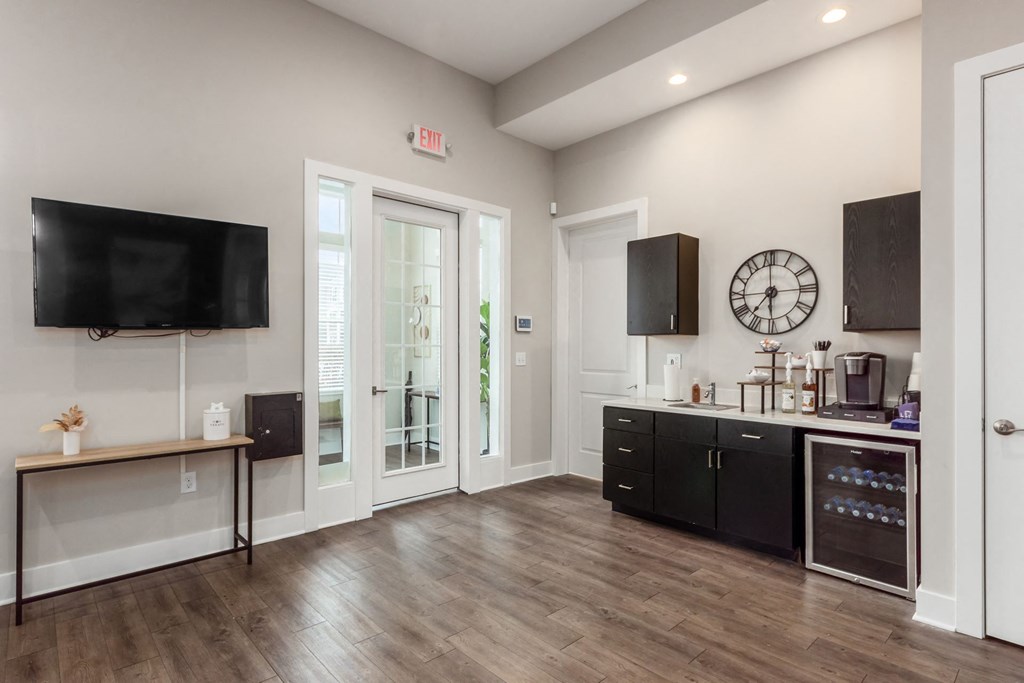 A kitchen with black cabinets and a wooden floor.