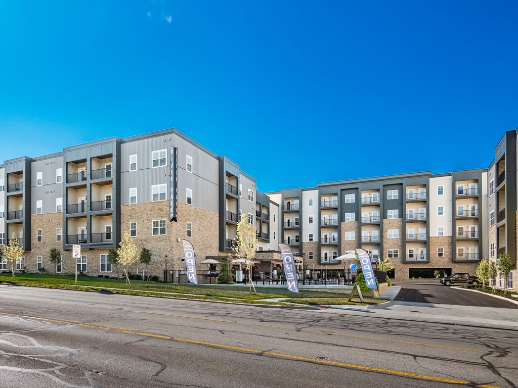 A large apartment complex with a parking lot in front.