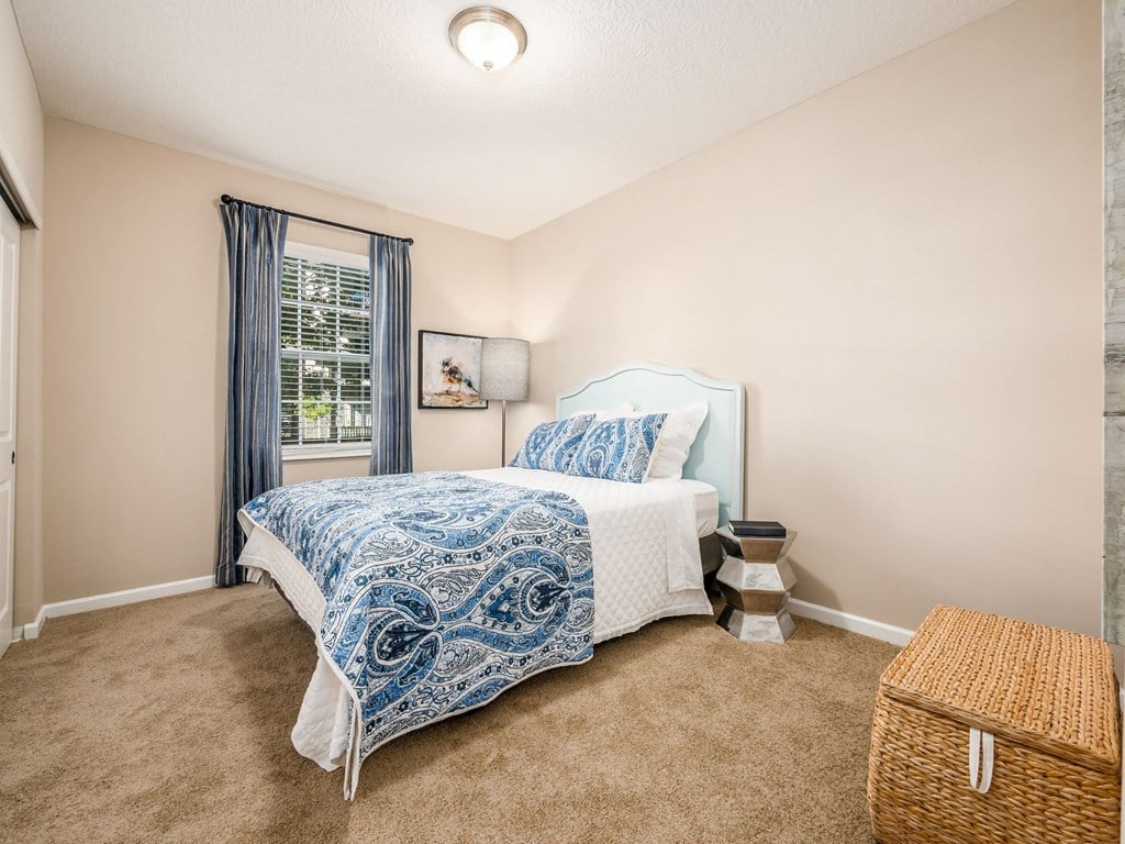 a bedroom with a bed and a wicker basket on the floor