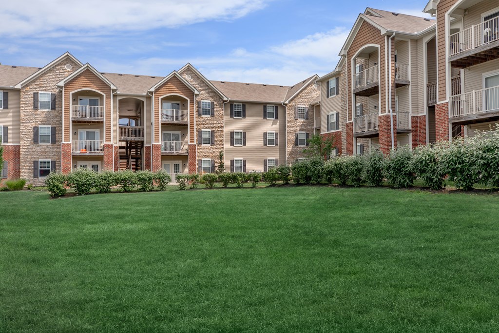 A large grassy area in front of apartment buildings.