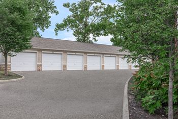 A two-story garage with white doors and a brown roof.