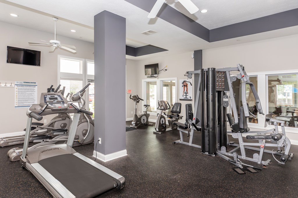 A gym with treadmills, weights, and exercise machines.