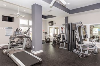 A gym with treadmills, weights, and exercise machines.