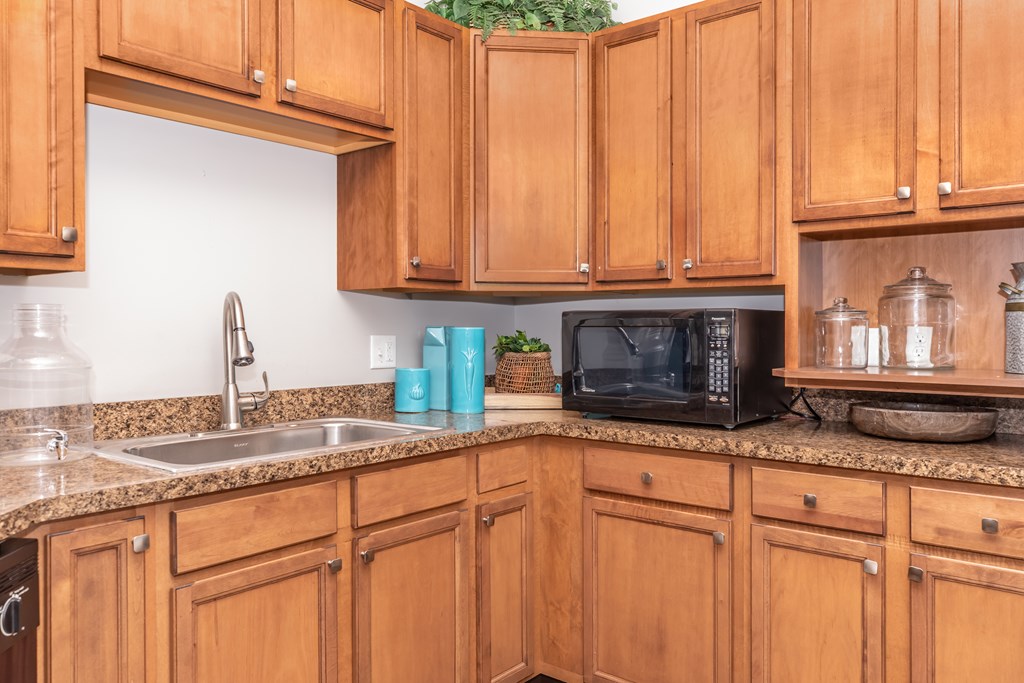 A kitchen with wooden cabinets and a granite countertop.