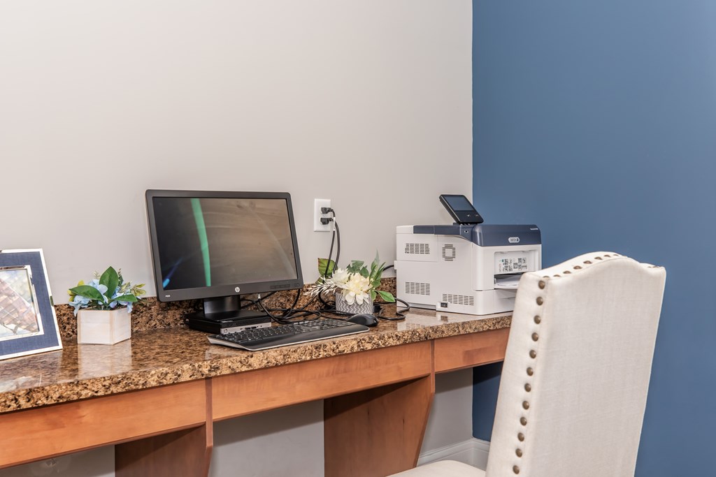 A desk with a laptop, monitor, and other items.