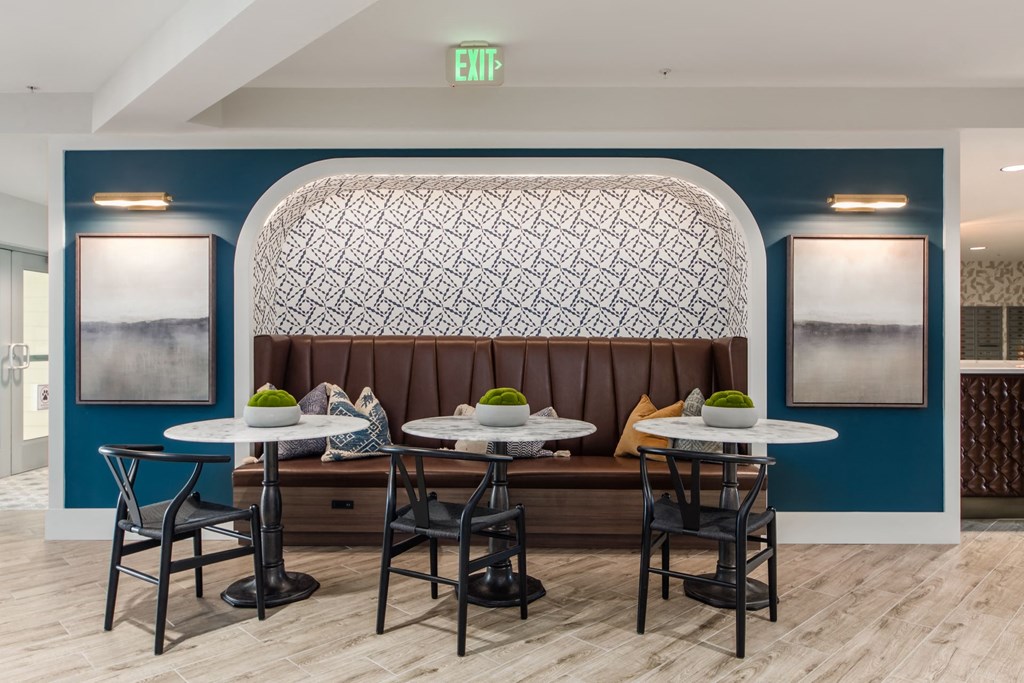 a dining room with tables and chairs in front of a wall with a large window