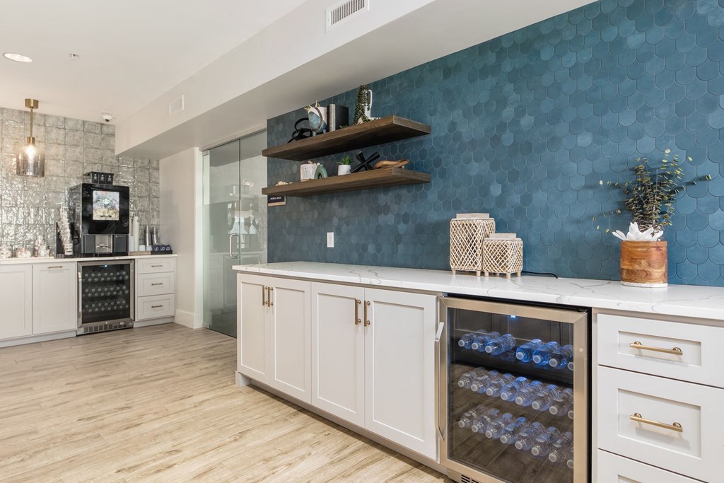 a kitchen with white cabinets and a blue wall