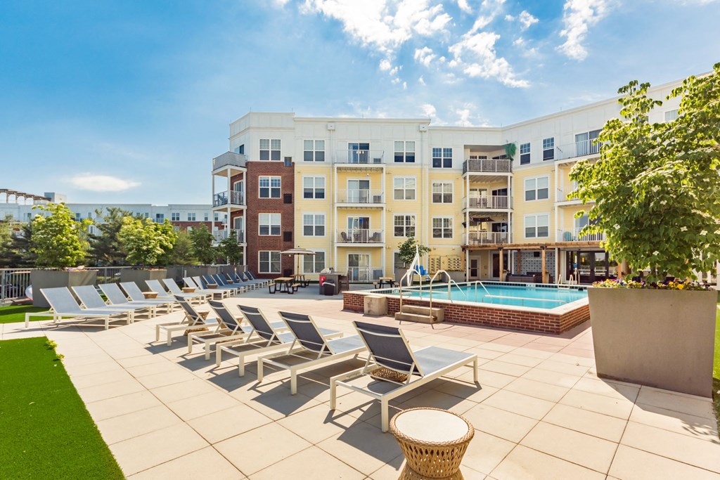 a swimming pool with lounge chairs and a building in the background