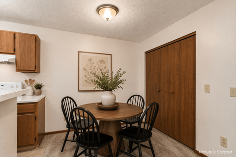 A dining room with a table and chairs.