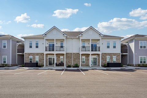 A row of houses with a parking lot in front.
