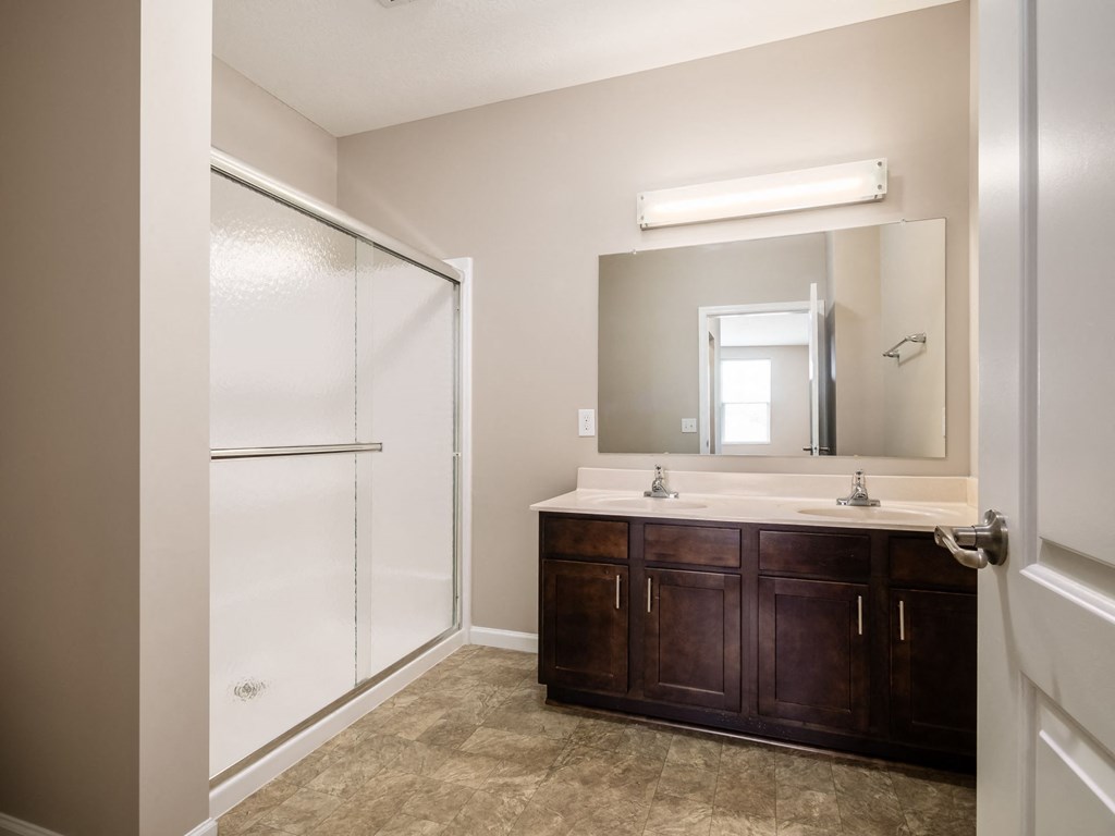 a bathroom with a sink and a shower and a mirror