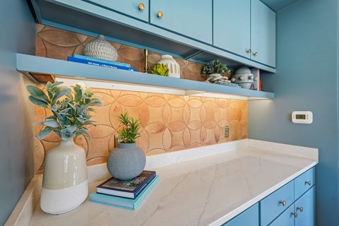 A kitchen counter with a vase and books on it.