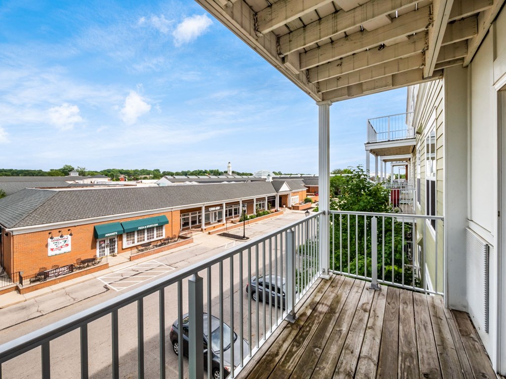 a balcony with a view of a building and a parking lot