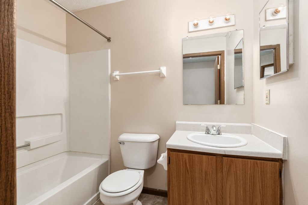a bathroom with a toilet sink and tub and a mirror