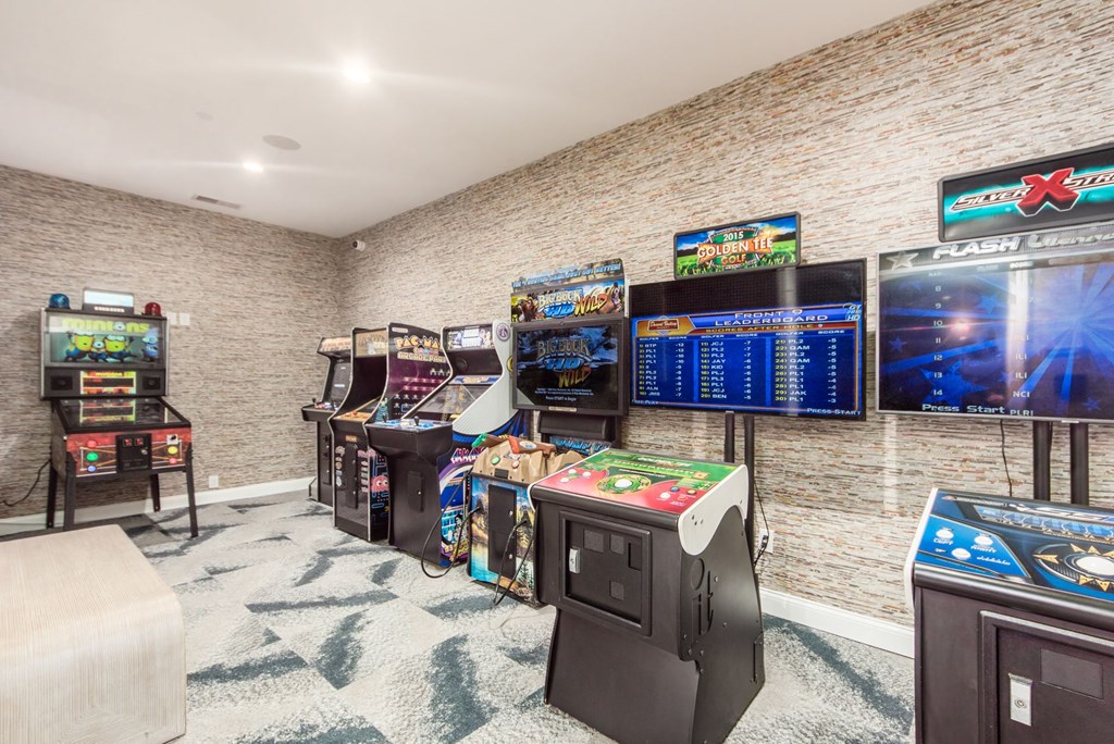 a gaming room with arcade games and televisions