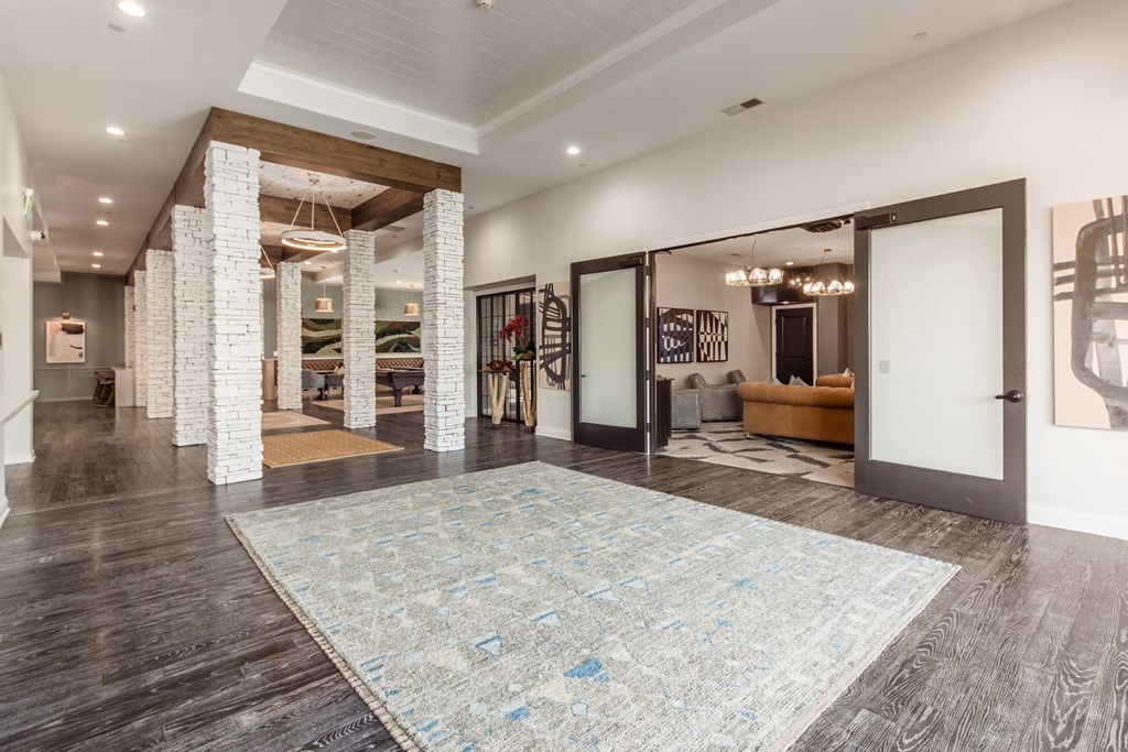 a living room with a large rug and a white door