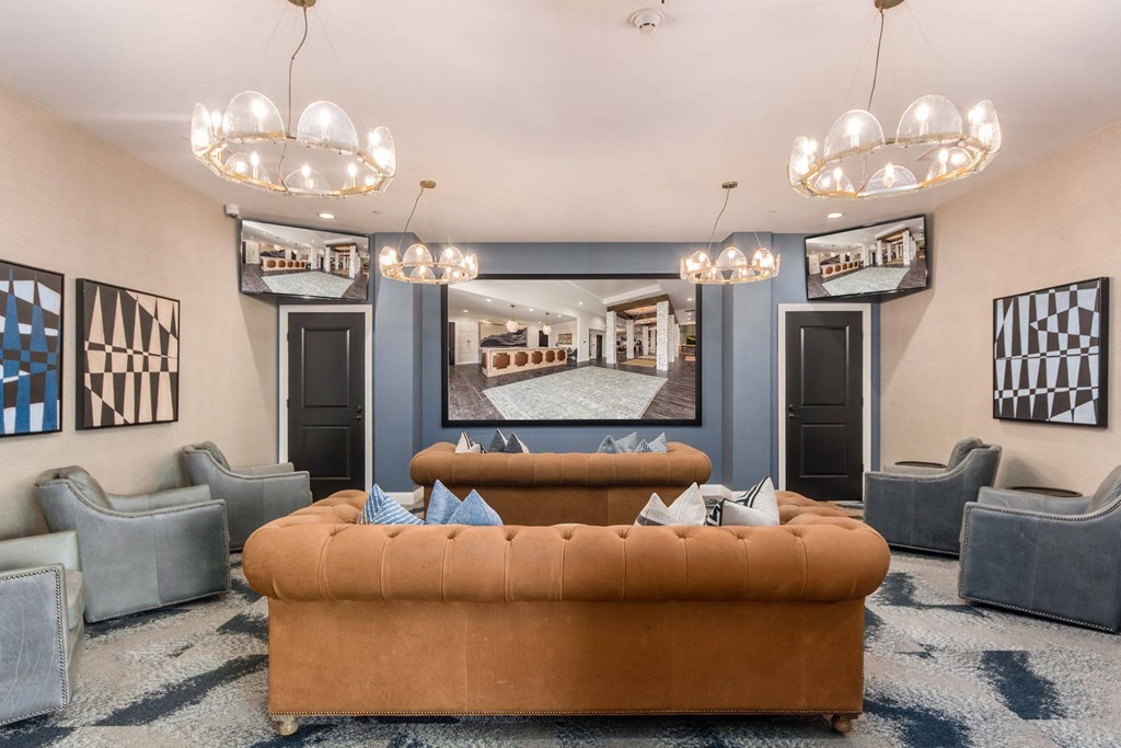 a living room with a couch and chairs in front of a mirror