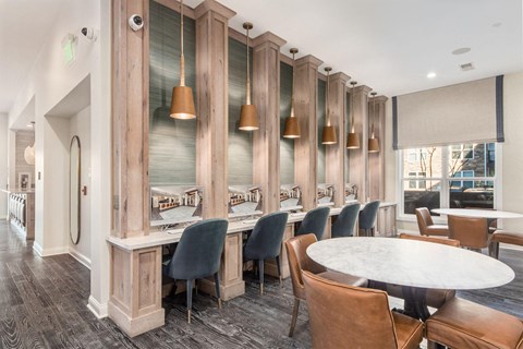 A dining room with a long table surrounded by chairs.
