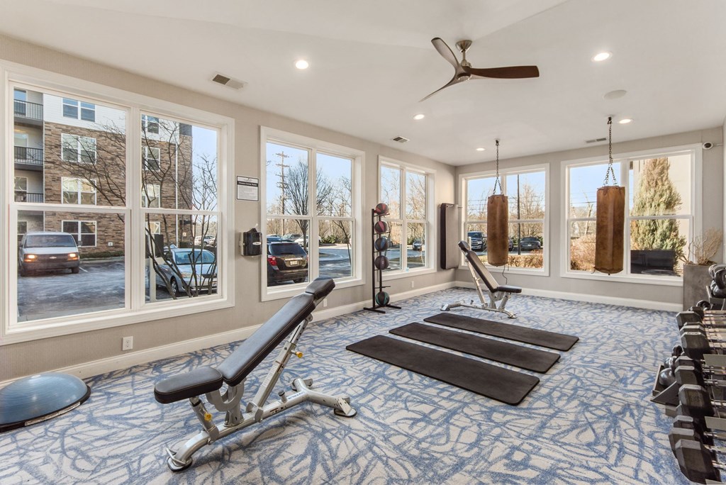 a workout room with weights and a ceiling fan