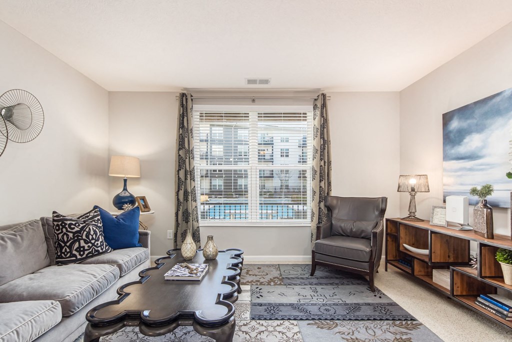 a living room with a couch and a chair and a window