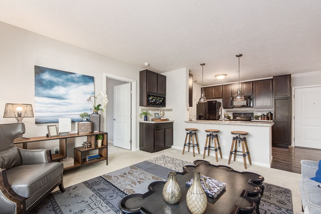 a living room with a kitchen with a bar and a couch