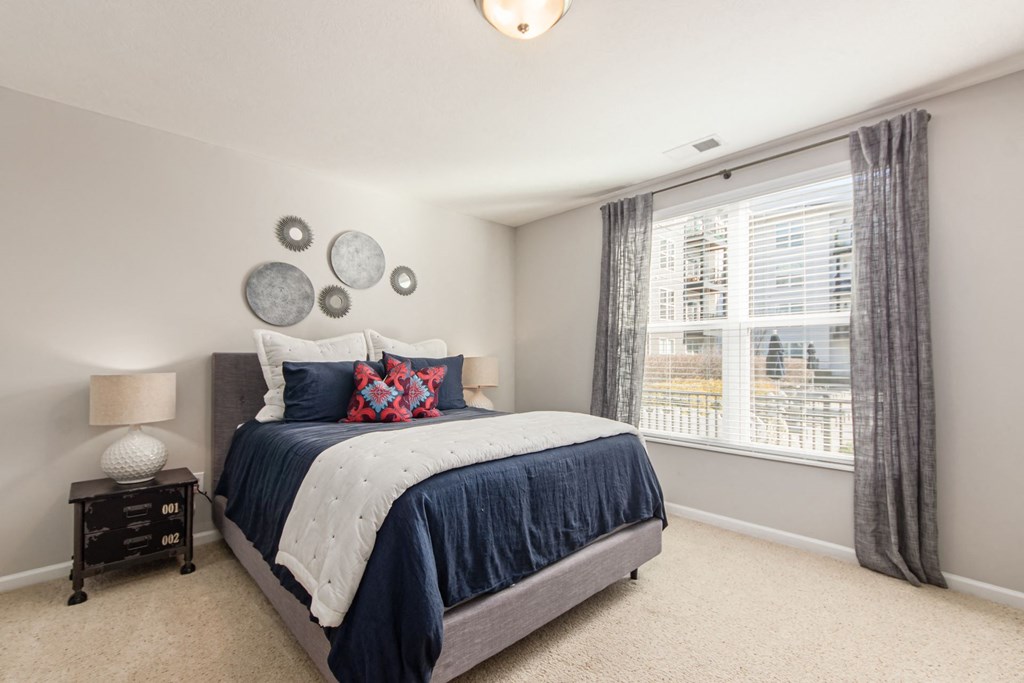 a bedroom with a bed and a large window