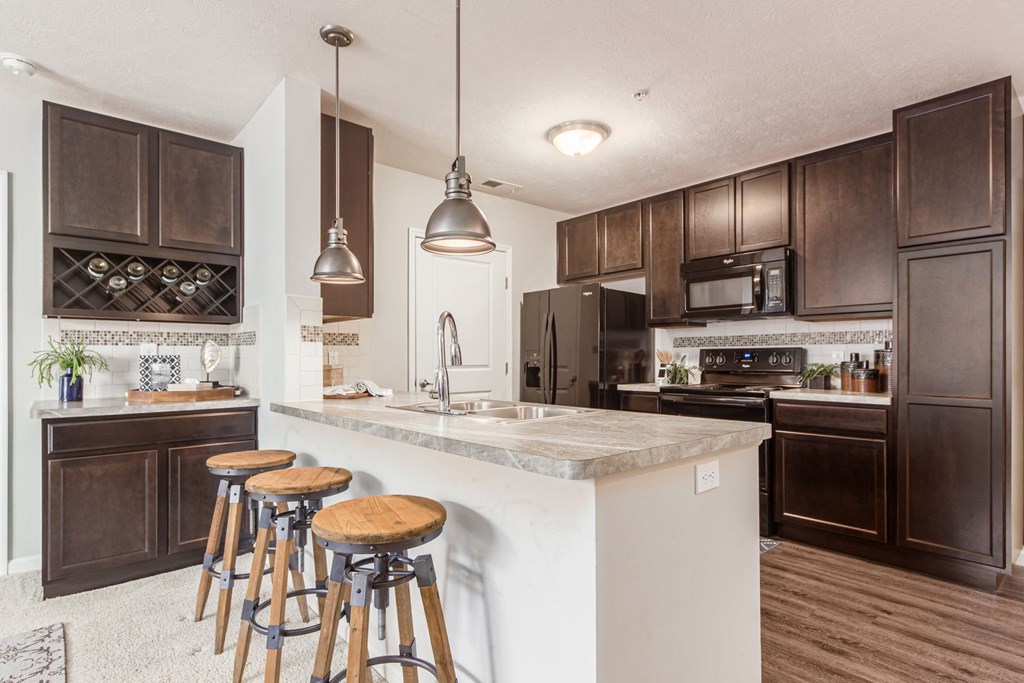 a kitchen with a large island with bar stools