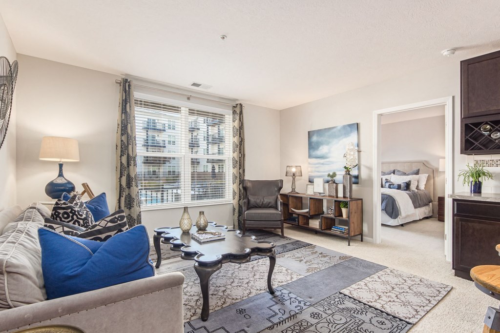 a living room with a couch and a chair in front of a window
