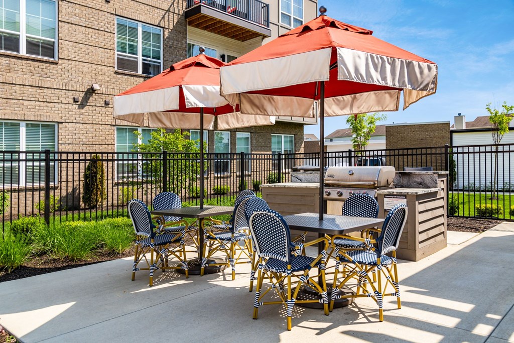 our patio has a grill and tables with umbrellas