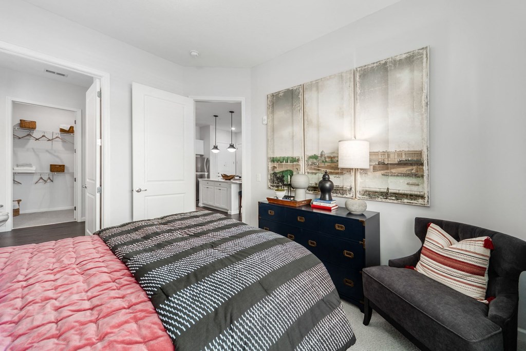 a bedroom with a bed and a chair and a dresser