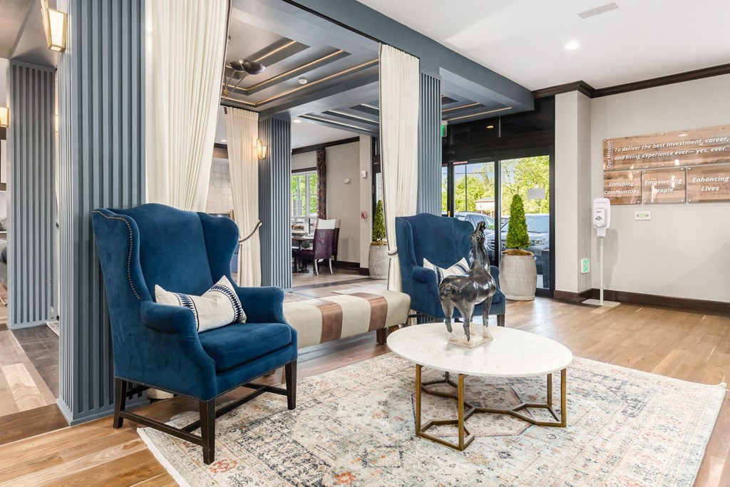 a living room with blue chairs and a dog on a table